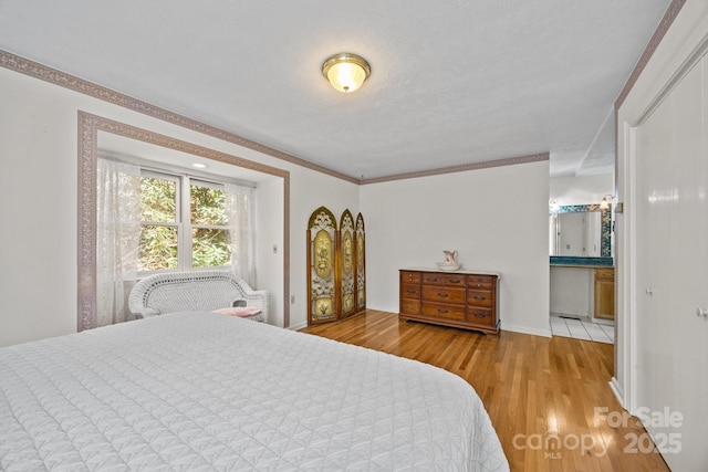 63 Chestnut Forest Rd, Fairview, NC 28730 - bedroom with baseboards, crown molding, connected bathroom, and light wood-type flooring