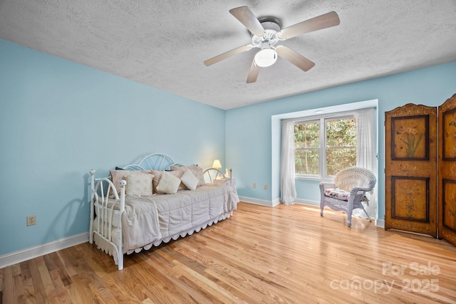 63 Chestnut Forest Rd, Fairview, NC 28730 - bedroom featuring a ceiling fan, a textured ceiling, baseboards, and light wood-style flooring
