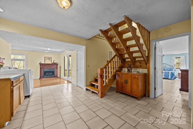 63 Chestnut Forest Rd, Fairview, NC 28730 - staircase featuring tile patterned flooring, a healthy amount of sunlight, a fireplace, and washer / clothes dryer
