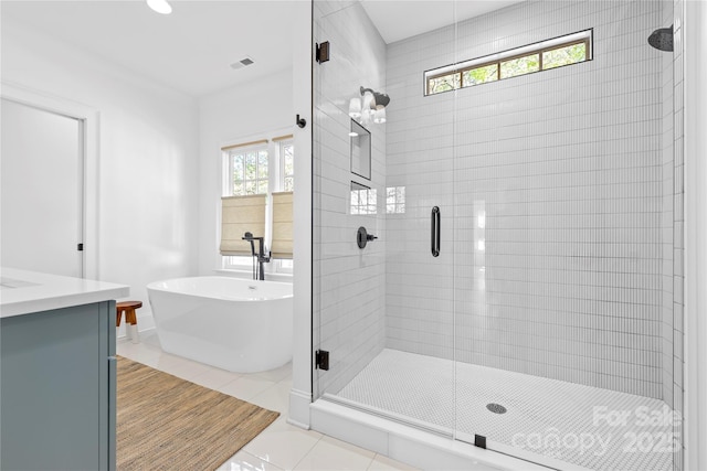 210 Walford Dr, Charlotte, NC 28208 - full bathroom featuring a shower stall, a freestanding tub, vanity, and tile patterned flooring