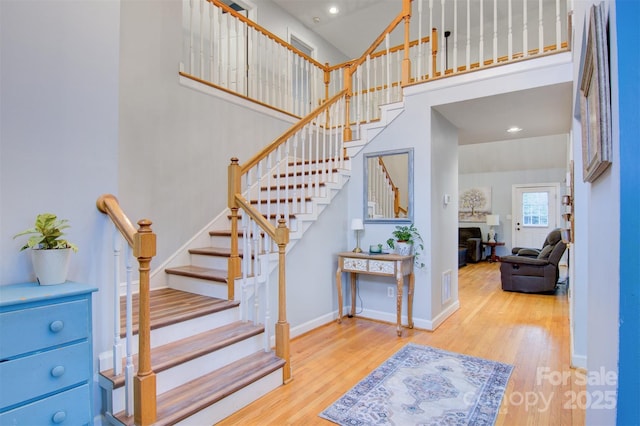 1050 Merrywood Dr, Newton, NC 28658 - staircase featuring a towering ceiling, baseboards, a fireplace, visible vents, and wood finished floors