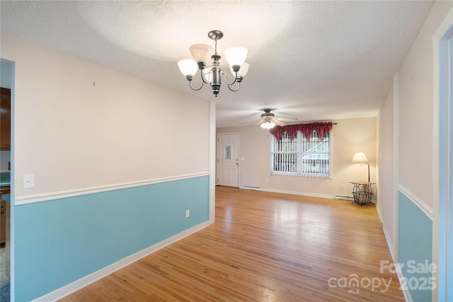 unfurnished room with baseboards, ceiling fan with notable chandelier, a textured ceiling, and wood finished floors