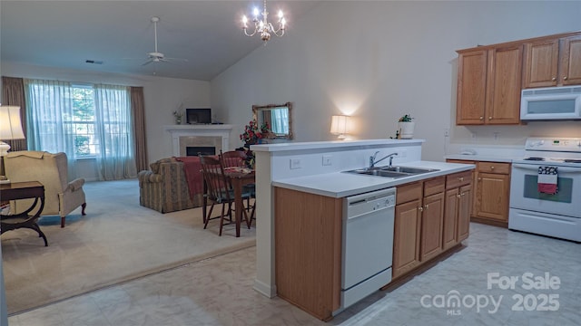 kitchen with a sink, open floor plan, a ceiling fan, white appliances, and a kitchen island with sink