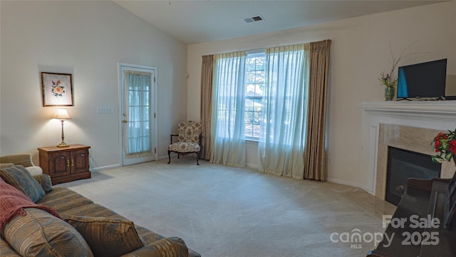 carpeted living room featuring baseboards, a fireplace, vaulted ceiling, and visible vents
