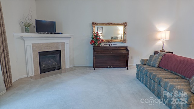 carpeted living area featuring a premium fireplace and baseboards