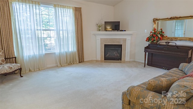 living area with carpet flooring, a tiled fireplace, and lofted ceiling