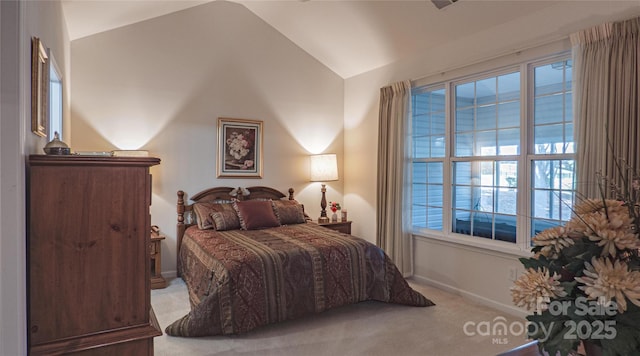 carpeted bedroom with baseboards and vaulted ceiling
