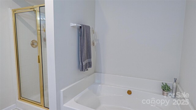 bathroom featuring a garden tub and a stall shower