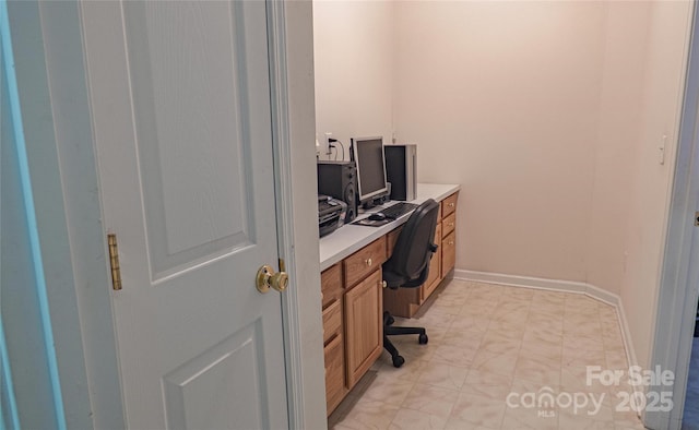 office space with baseboards and light floors
