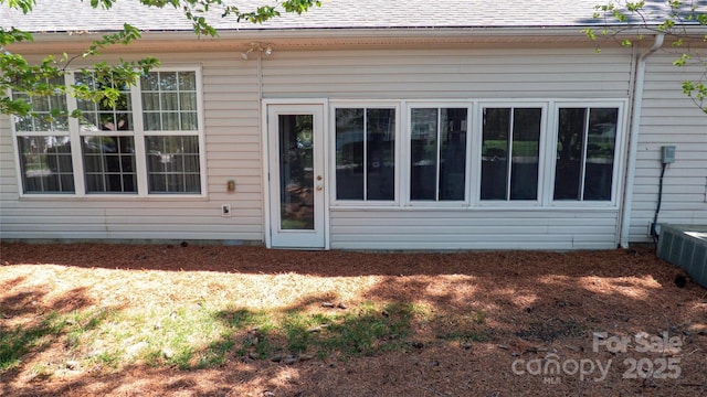 rear view of property with roof with shingles