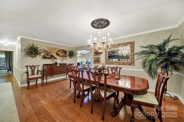 dining room featuring crown molding, wood finished floors, and a notable chandelier