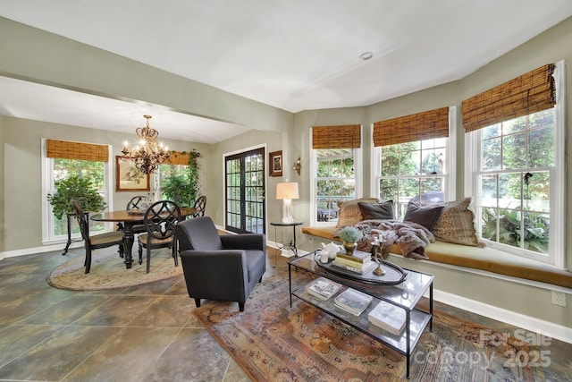living room with baseboards and a notable chandelier