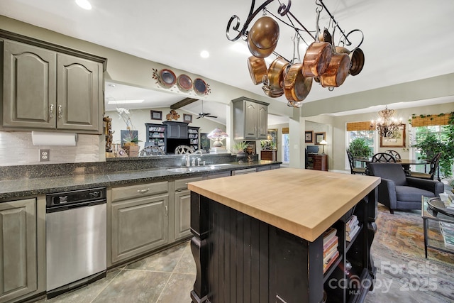 kitchen featuring a center island, tasteful backsplash, a sink, an inviting chandelier, and wood counters