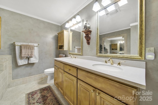 bathroom featuring a sink, ornamental molding, toilet, and double vanity