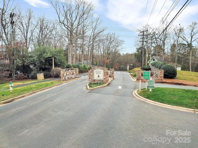 view of road with a gated entry and curbs