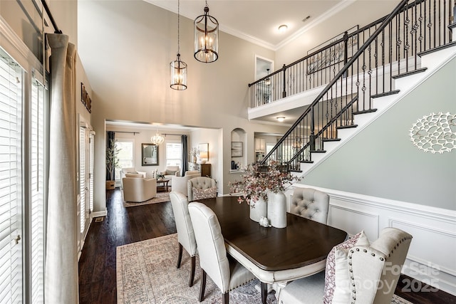 405 Five Leaf Ln, Waxhaw, NC 28173 - dining space featuring a towering ceiling, a chandelier, stairway, crown molding, and wood finished floors