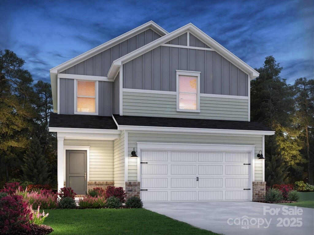 view of front of house with board and batten siding, a garage, stone siding, and concrete driveway