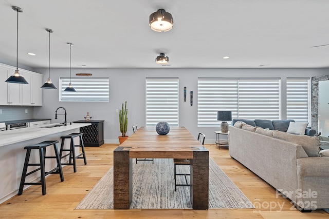 dining area with light wood-type flooring, a healthy amount of sunlight, and baseboards