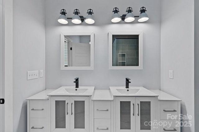 full bath featuring a sink and two vanities