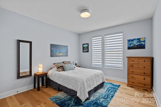 bedroom with light wood finished floors and baseboards