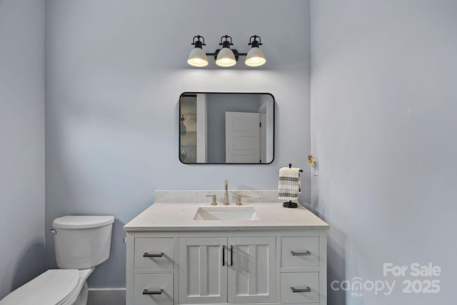 half bathroom with toilet and vanity