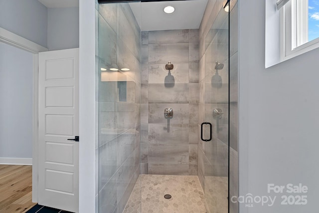 bathroom with recessed lighting, a stall shower, and wood finished floors