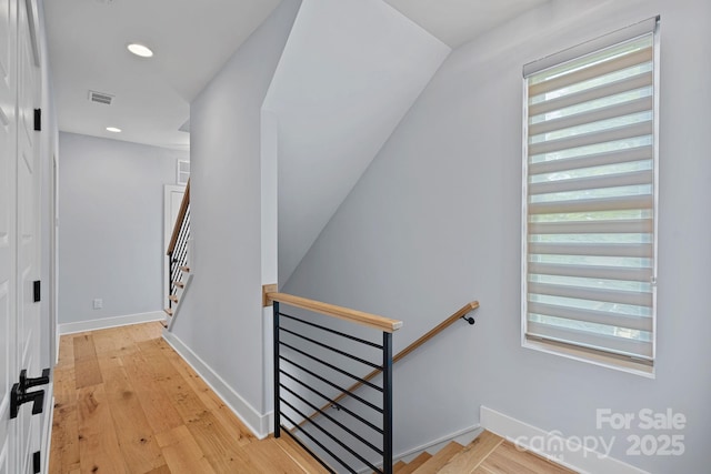 staircase with vaulted ceiling, visible vents, recessed lighting, wood finished floors, and baseboards