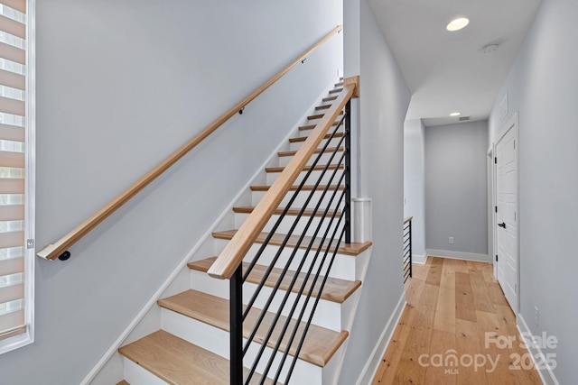 stairway with wood-type flooring, baseboards, and recessed lighting