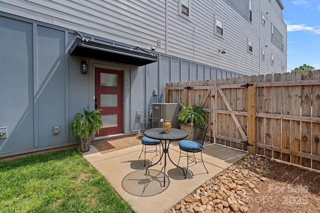 view of patio featuring cooling unit, fence, and a gate
