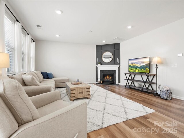 5532 Muckross Ln, Fort Mill, SC 29707 - living area featuring a fireplace with flush hearth, wood finished floors, visible vents, and recessed lighting