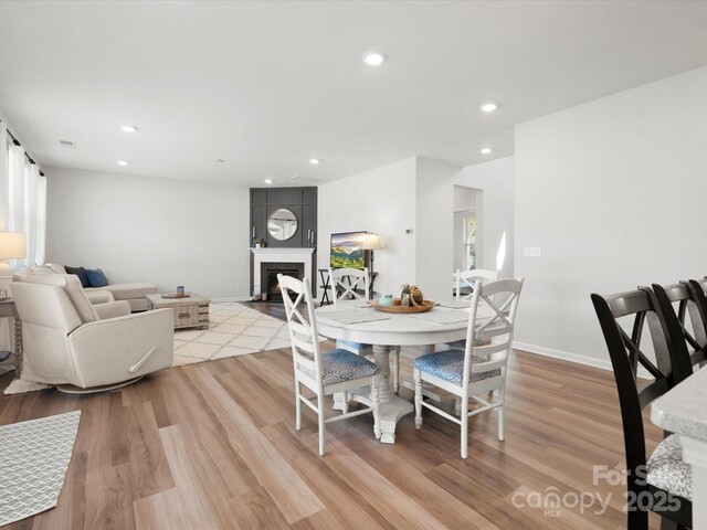 5532 Muckross Ln, Fort Mill, SC 29707 - dining area featuring recessed lighting, light wood-type flooring, baseboards, and a warm lit fireplace