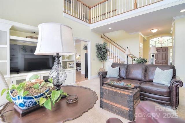 living room with ornamental molding, recessed lighting, stairway, a high ceiling, and baseboards