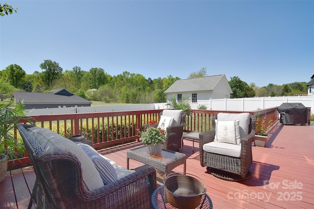 deck featuring a grill, fence, and an outdoor hangout area