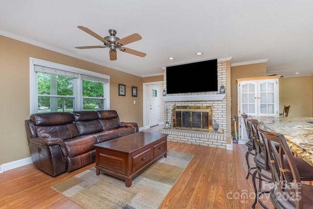 living area featuring crown molding, a ceiling fan, and light wood-type flooring