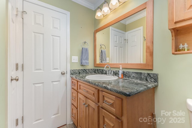 bathroom with vanity, ornamental molding, and toilet