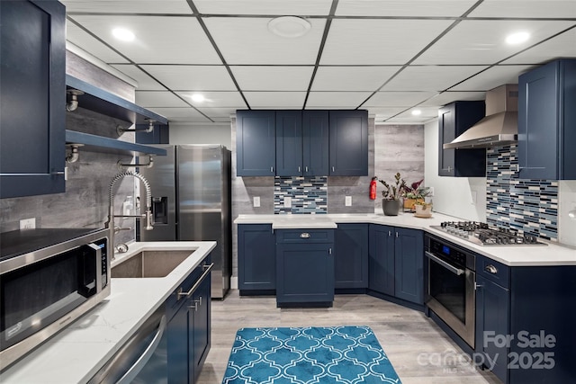 34 Turnberry Dr, Arden, NC 28704 - kitchen featuring decorative backsplash, blue cabinetry, wall chimney exhaust hood, and stainless steel appliances