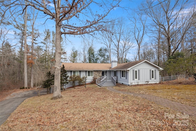 34 Turnberry Dr, Arden, NC 28704 - ranch-style house with board and batten siding, a front yard, fence, a chimney, and driveway