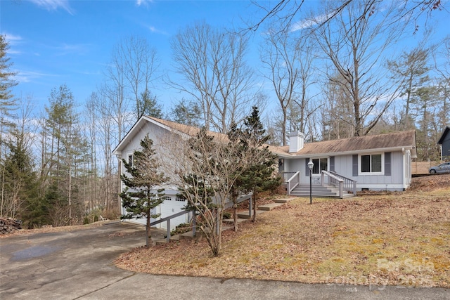 34 Turnberry Dr, Arden, NC 28704 - view of front of home featuring board and batten siding, an attached garage, driveway, and a chimney