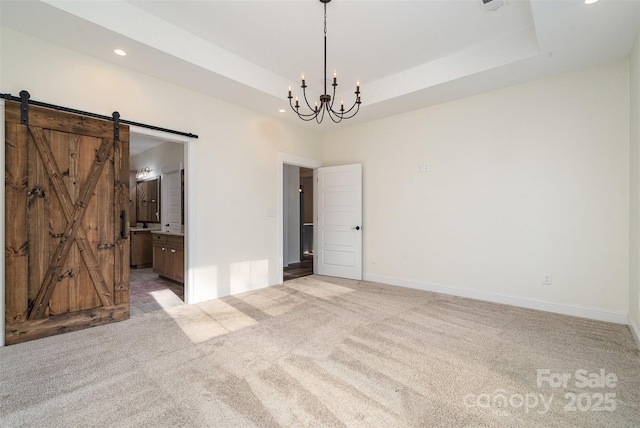 spare room featuring a barn door, a notable chandelier, recessed lighting, and light colored carpet