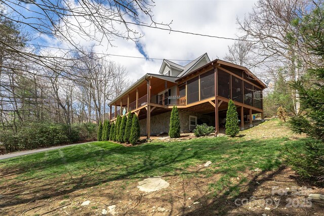 exterior space with a sunroom and a lawn