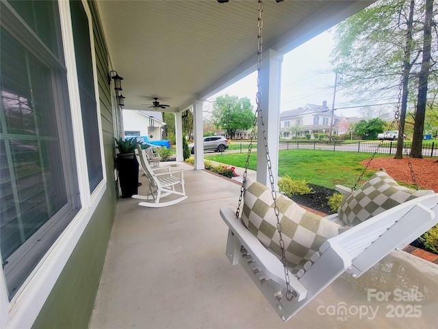 view of patio / terrace featuring a porch and fence