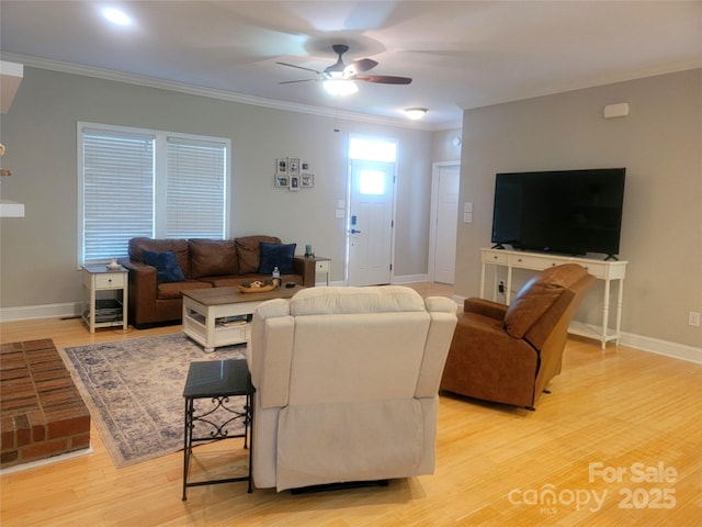 living area with crown molding, baseboards, a ceiling fan, and light wood-type flooring