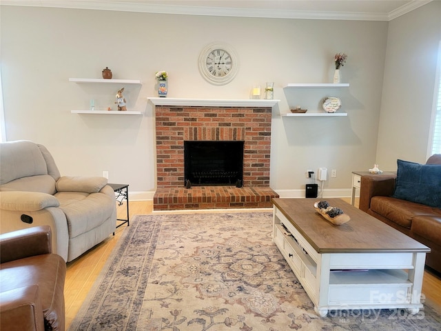living room with crown molding, baseboards, light wood-type flooring, and a brick fireplace