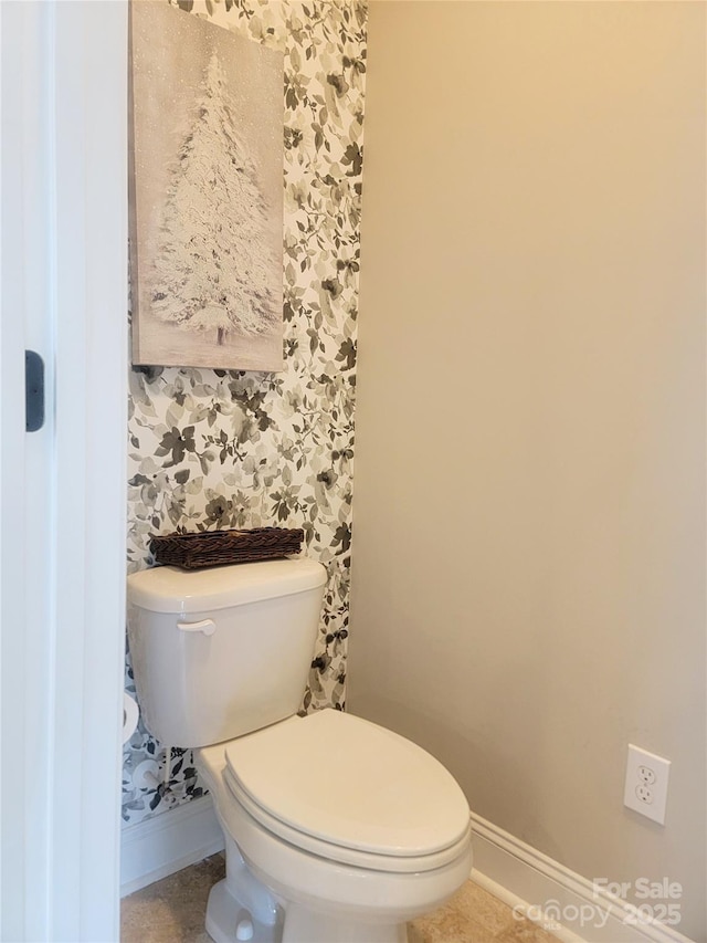 bathroom featuring tile patterned flooring, baseboards, and toilet