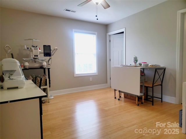 office area with visible vents, ceiling fan, light wood-style floors, and baseboards