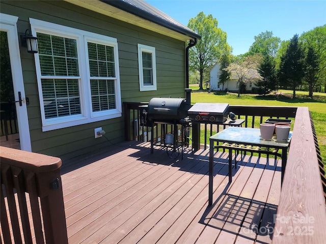 wooden deck with grilling area and a lawn