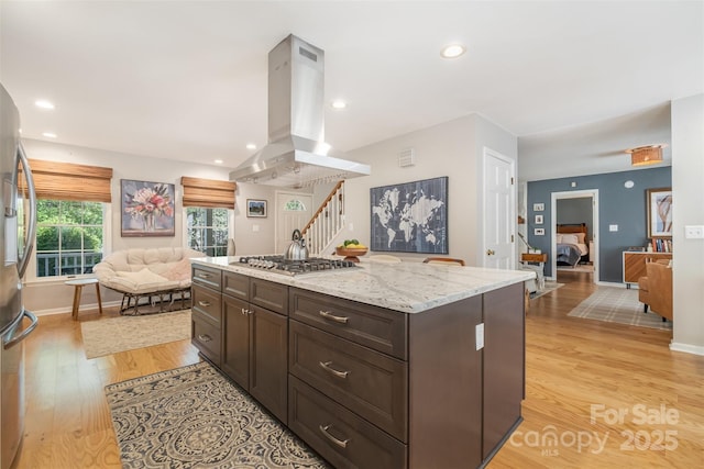 127 Fantasy Ln, Mooresville, NC 28117 - kitchen featuring open floor plan, island exhaust hood, light wood finished floors, stainless steel appliances, and light stone counters