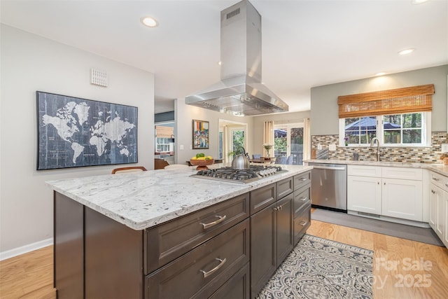 127 Fantasy Ln, Mooresville, NC 28117 - kitchen with appliances with stainless steel finishes, island range hood, a sink, white cabinetry, and light stone counters