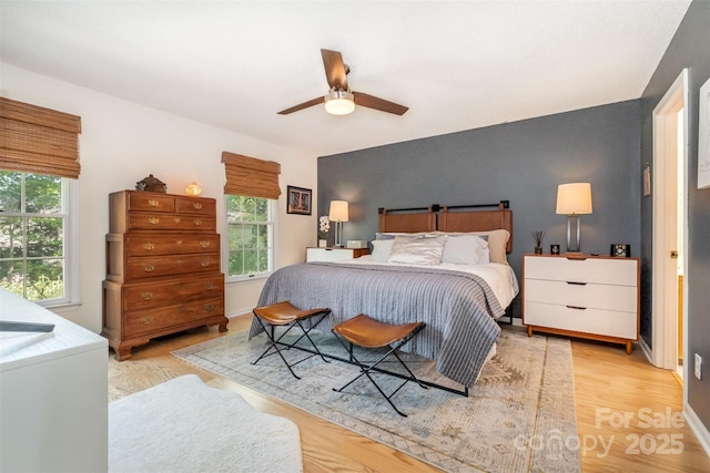 127 Fantasy Ln, Mooresville, NC 28117 - bedroom with an accent wall, a ceiling fan, and light wood finished floors