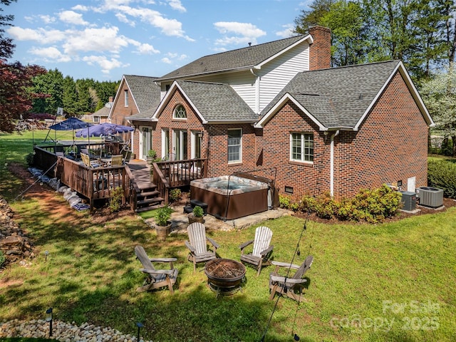 127 Fantasy Ln, Mooresville, NC 28117 - rear view of property featuring a hot tub, an outdoor fire pit, roof with shingles, brick siding, and a yard